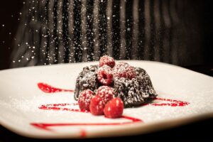 Elegantly Plated Dessert being frosted with powdered sugard